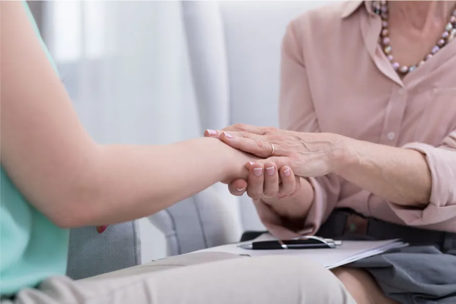 A clinician holding a patient's hand